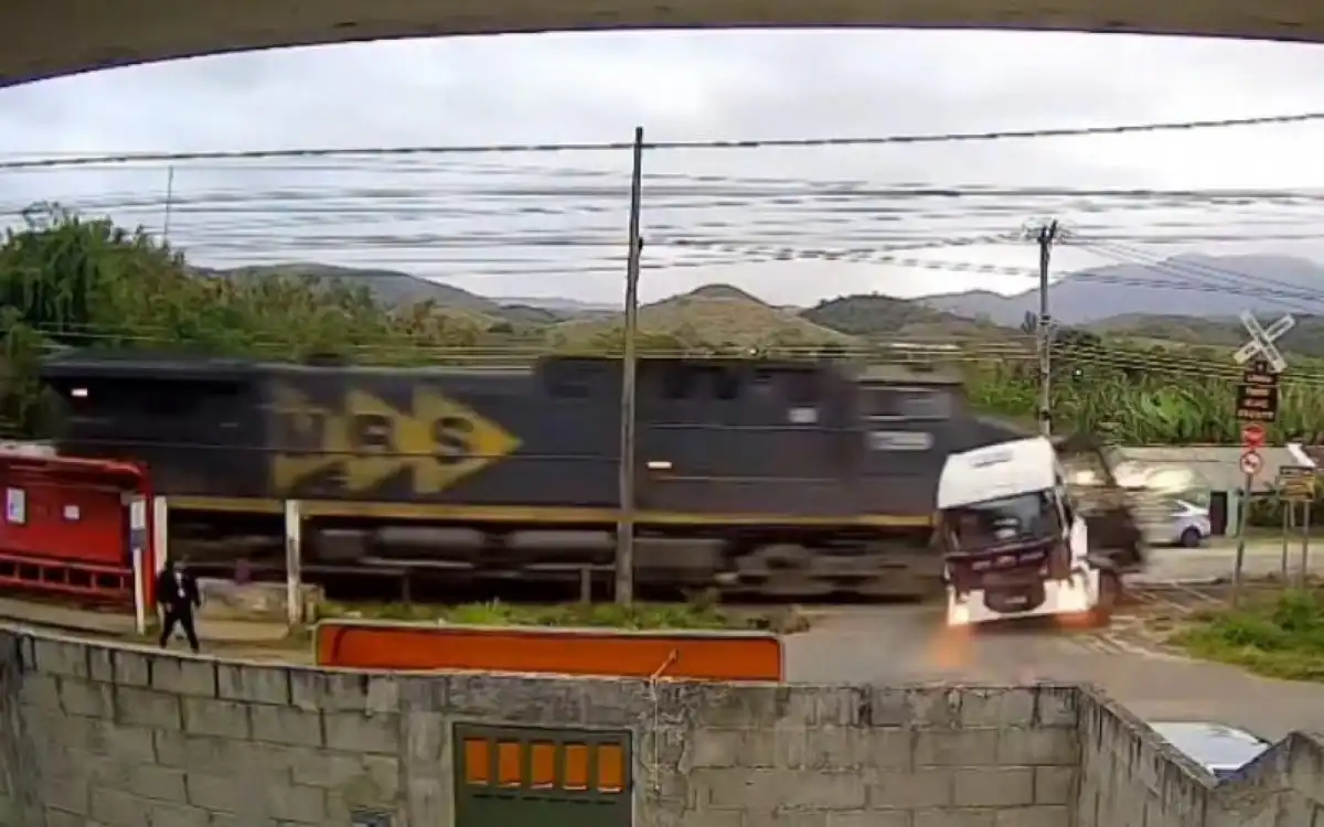 Caminhão é atingido por trem ao tentar atravessar linha-férrea; vídeo viralizou 