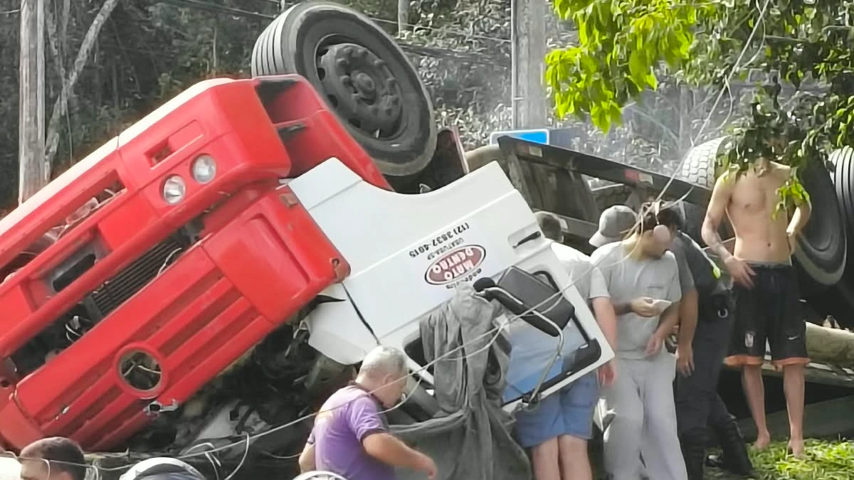 Caminhão carregado de madeira tomba na Tamoios em Caraguatatuba