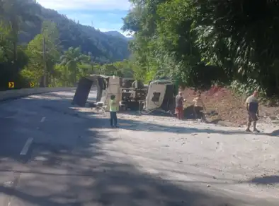 Caminhão carregado de areia tomba na serra antiga da Tamoios; Motorista fica ferido