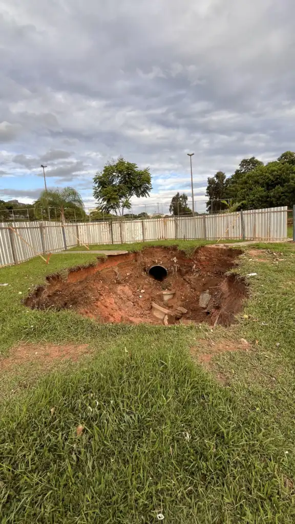 cratera no Jd Satélite. em volta há tapumes para proteger o local