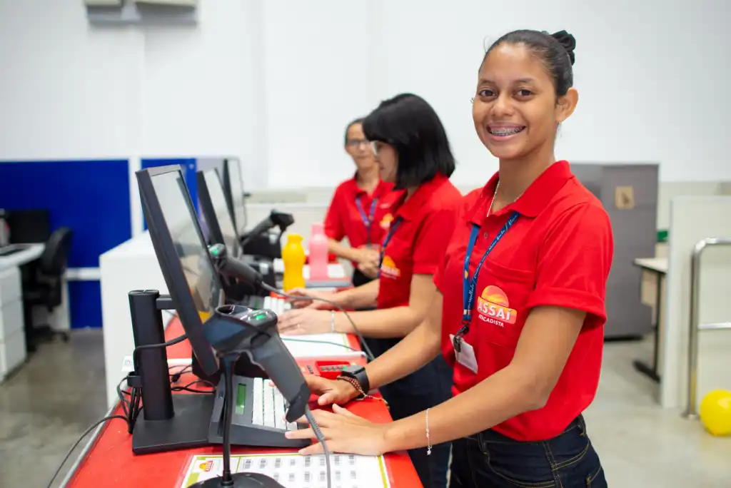 foto das funcionárias do assaí em frente aos commputadores do mercado