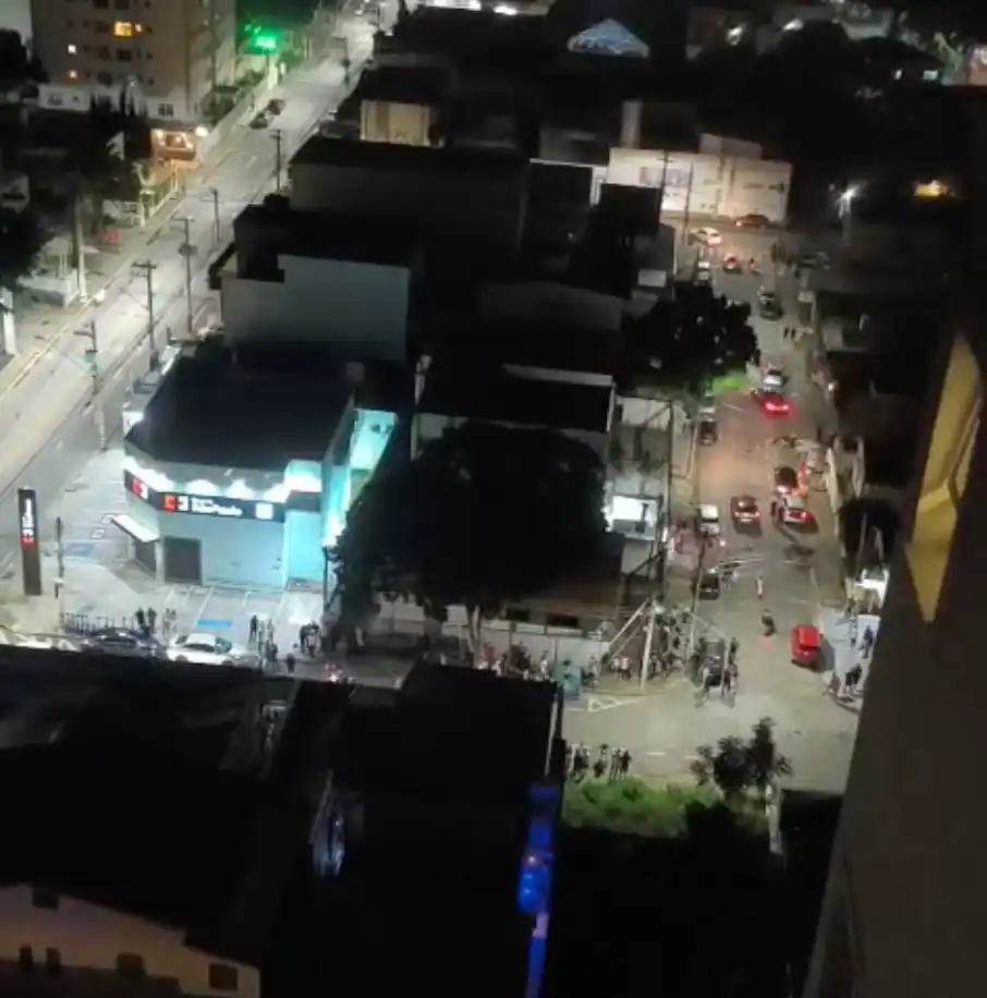 imagem aérea gravada por um morador de prédio. na rua aparece um grupo de motos